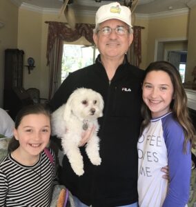 grandfather holding dog with grandchildren
